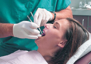 photo of a relaxed woman in a dental chair being examined by a dentist who caters to cowards