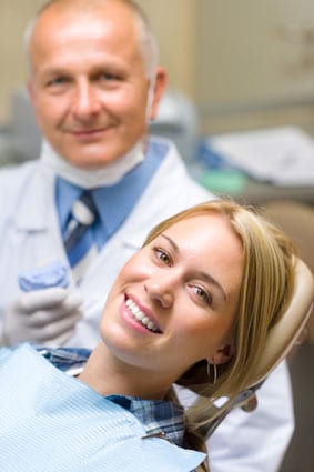 Patient and dentist smiling.