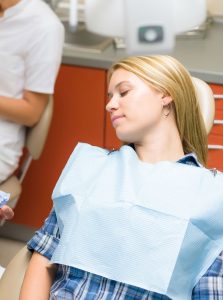 Young woman asleep in the dental chair from dental sedation